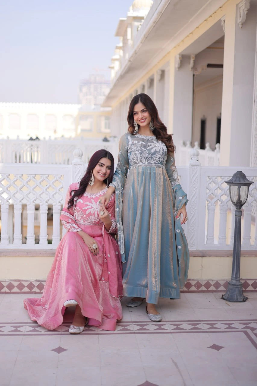Two women in traditional outfits standing in front of a white building with columns.